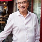 01582-2793994351-portrait-face-photo-of-CarmDold-man-65-years-old-wearing-a-white-linen-shirt-and-jeans-standing-outside-a-cafe-smile-up-c