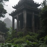 08719-3200736024-horror-themed-a-dense-tropical-rainforestwith-an-ancient-temple-visible-in-the-distance.-The-scene-is-shrouded-in-a-light-mist